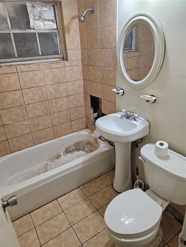 bathroom with tile patterned floors, toilet, and tiled shower / bath combo