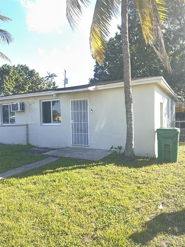 back of house featuring a yard and a wall mounted AC