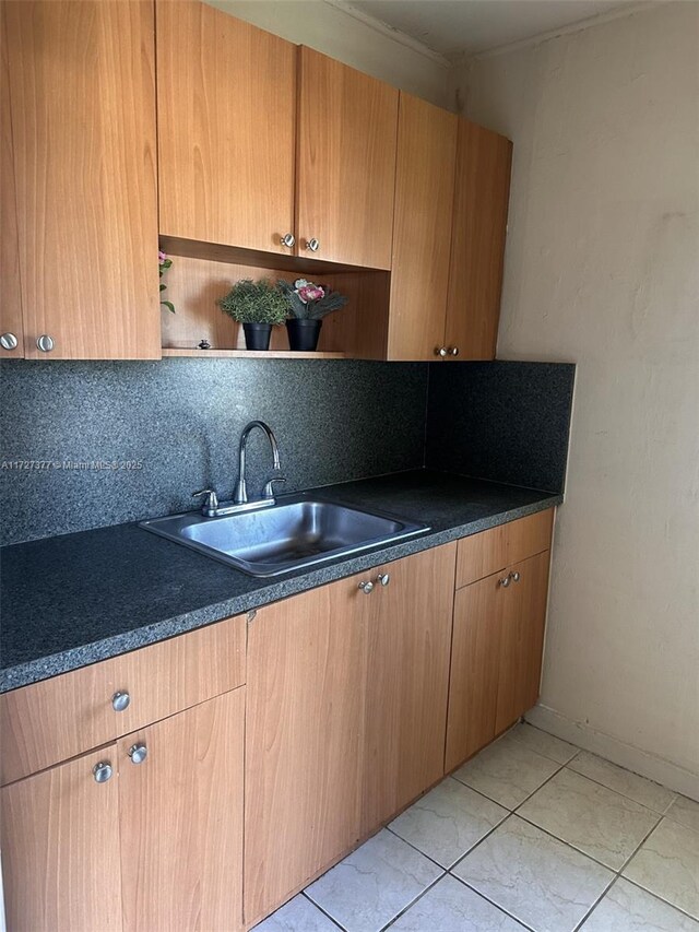 kitchen featuring sink, backsplash, and light tile patterned flooring