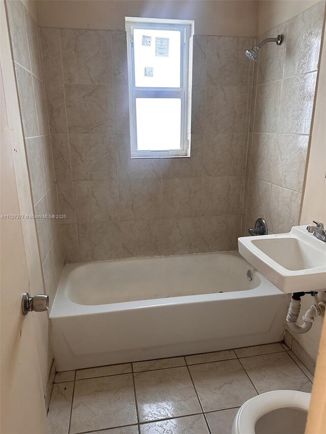 full bathroom with toilet, tiled shower / bath combo, tile patterned floors, and sink