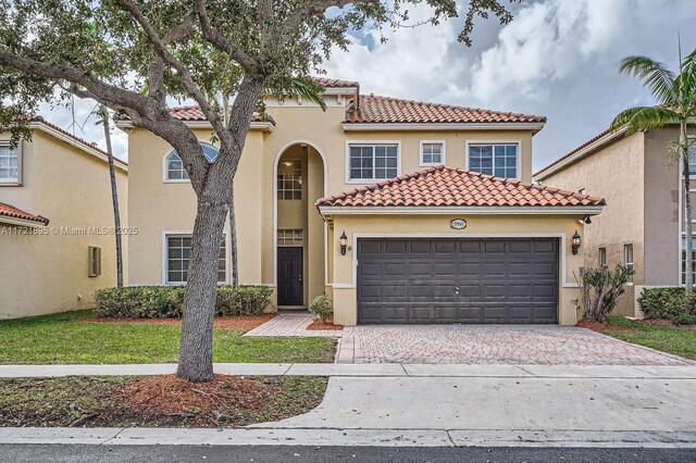 mediterranean / spanish home with a garage and a front yard