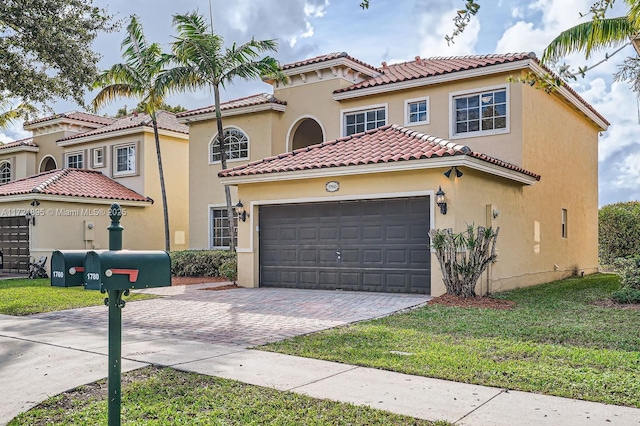 mediterranean / spanish-style home with a front yard and a garage