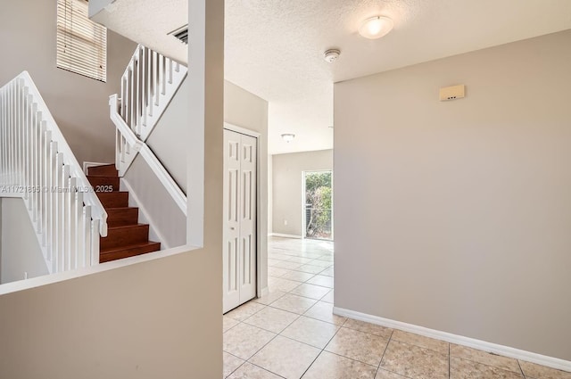 interior space featuring a textured ceiling and light tile patterned flooring