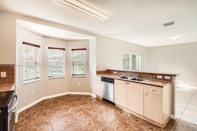 kitchen featuring dishwasher, sink, light tile patterned floors, electric stove, and a textured ceiling