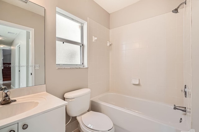 full bathroom featuring tiled shower / bath combo, toilet, and vanity