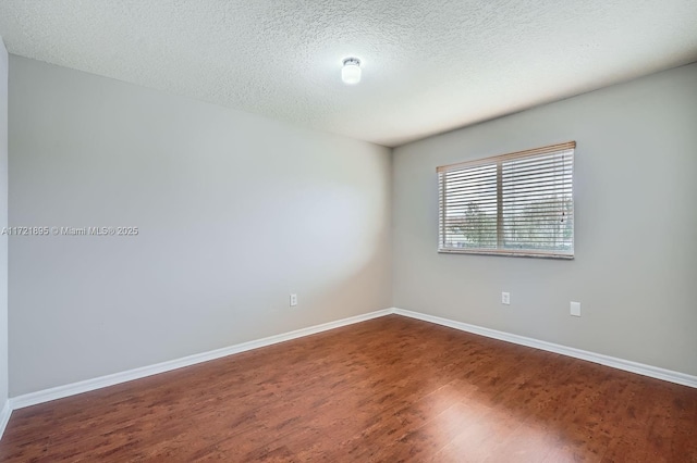 spare room with wood-type flooring and a textured ceiling