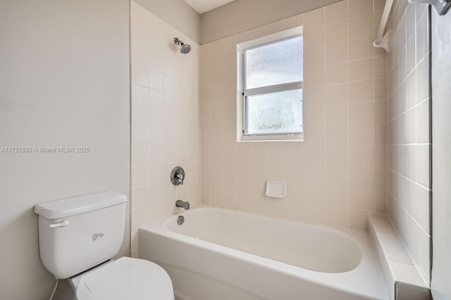 bathroom featuring toilet and tiled shower / bath