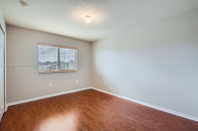 spare room featuring wood-type flooring and a textured ceiling