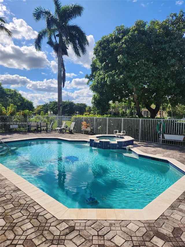 view of swimming pool featuring an in ground hot tub and a patio area