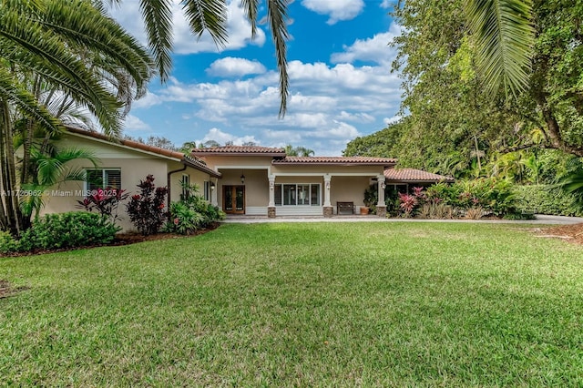 rear view of property featuring a lawn