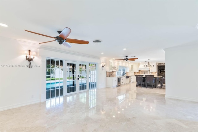 unfurnished living room featuring ceiling fan, french doors, and crown molding