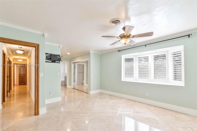 empty room featuring ceiling fan and ornamental molding