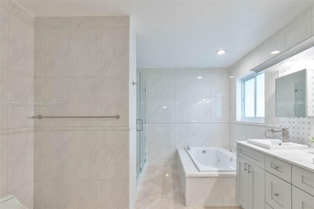 bathroom with separate shower and tub, vanity, and tile walls