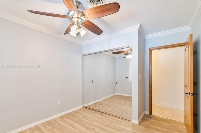 unfurnished bedroom with ceiling fan, a closet, ornamental molding, and light hardwood / wood-style flooring