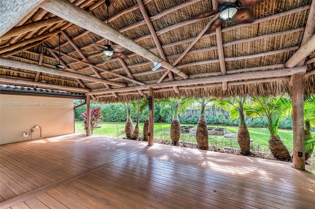 wooden terrace with ceiling fan, a gazebo, and a lawn