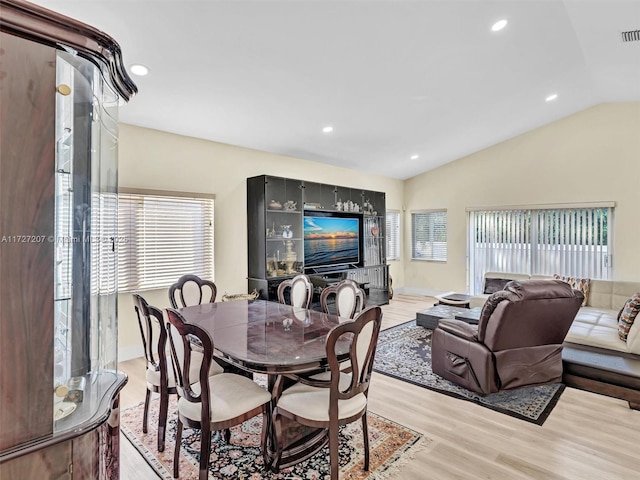 dining space with lofted ceiling and light hardwood / wood-style floors