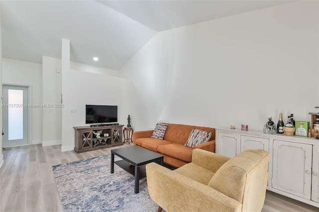 living room featuring light hardwood / wood-style flooring and vaulted ceiling