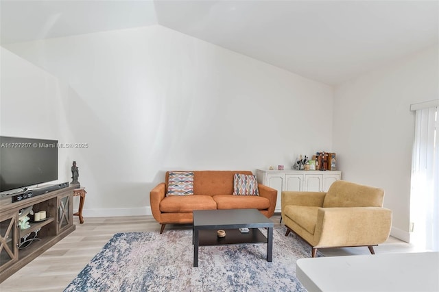 living room featuring vaulted ceiling and light wood-type flooring