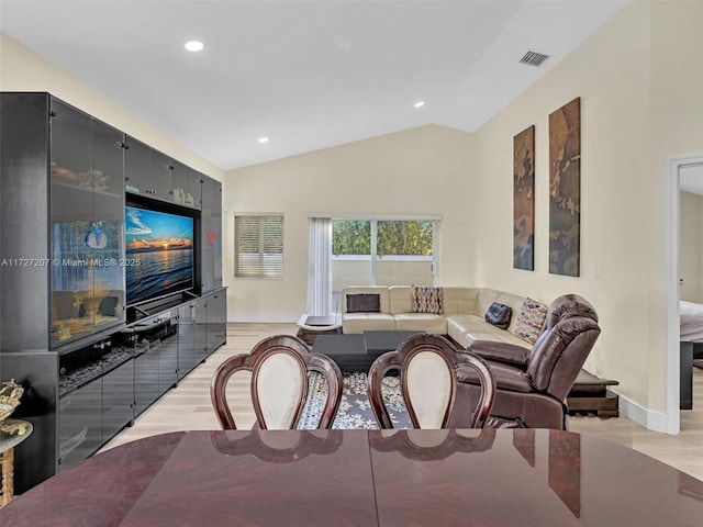 dining room featuring lofted ceiling and light hardwood / wood-style floors