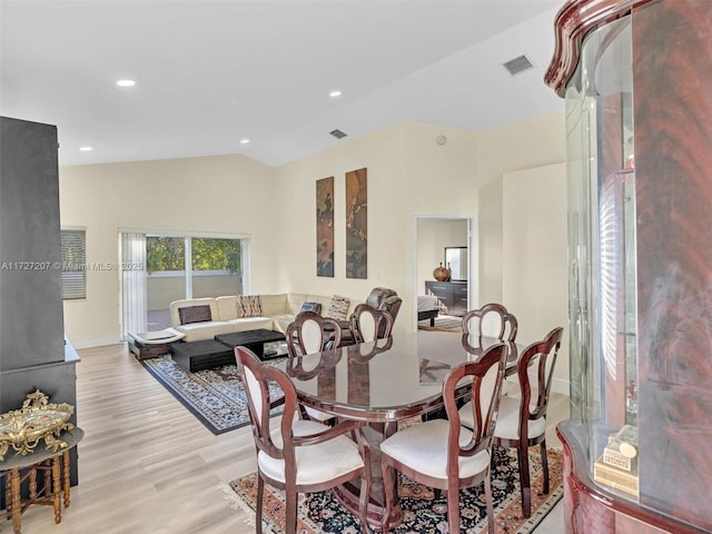 dining room featuring light hardwood / wood-style flooring and vaulted ceiling