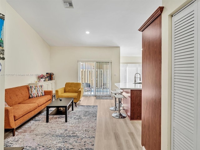 living room with sink and light hardwood / wood-style floors