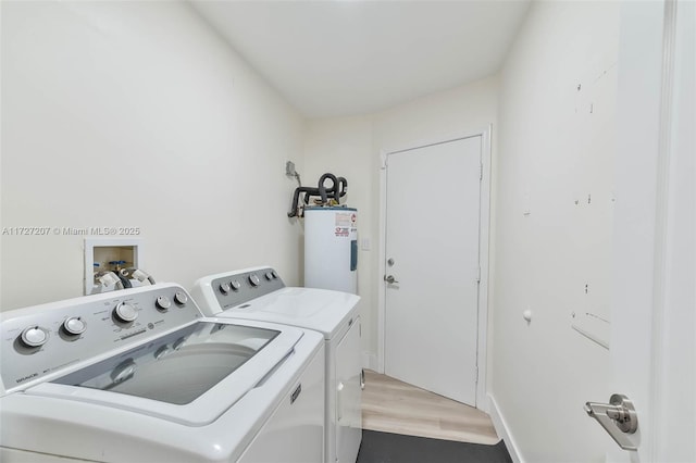 laundry area with hardwood / wood-style flooring, electric water heater, and independent washer and dryer