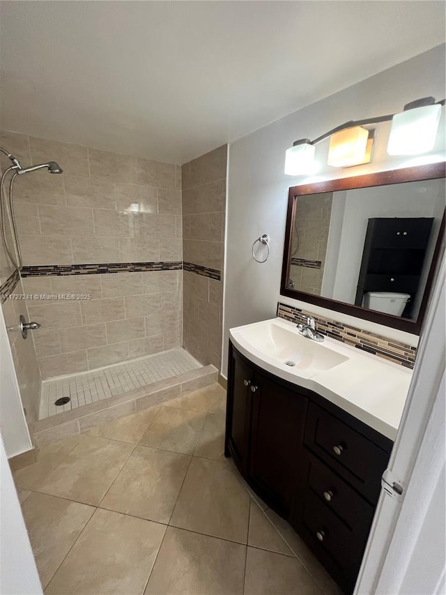 bathroom featuring vanity, tile patterned floors, and tiled shower