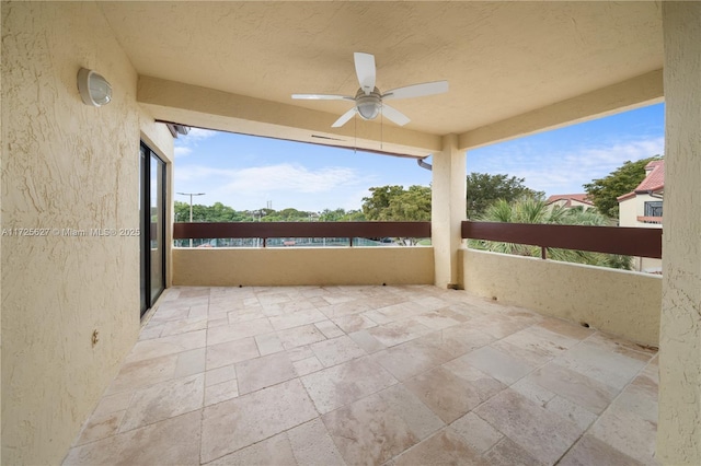 view of patio with ceiling fan and a balcony