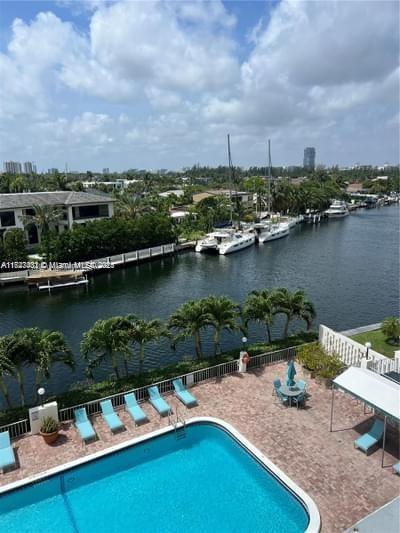 view of swimming pool with a water view and a patio