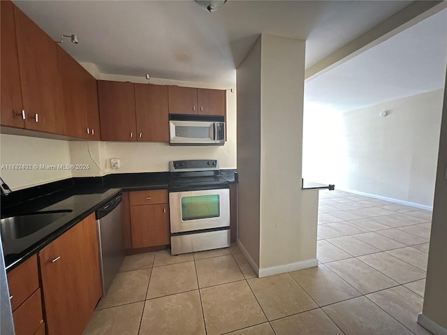 kitchen featuring light tile patterned flooring and stainless steel appliances