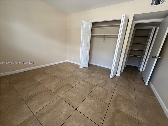 unfurnished bedroom with a closet and tile patterned flooring