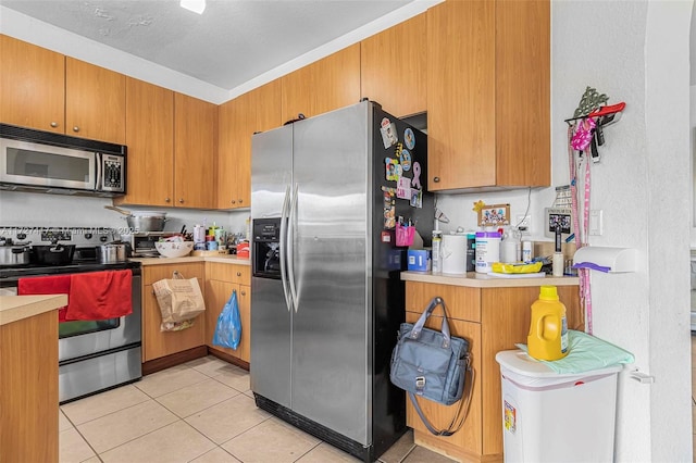 kitchen with stainless steel appliances and light tile patterned floors