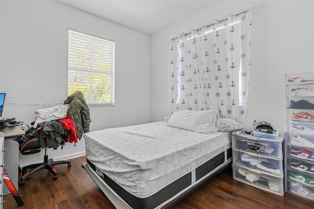 bedroom with dark hardwood / wood-style flooring