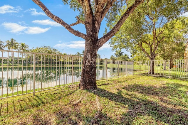 view of yard featuring a water view and fence