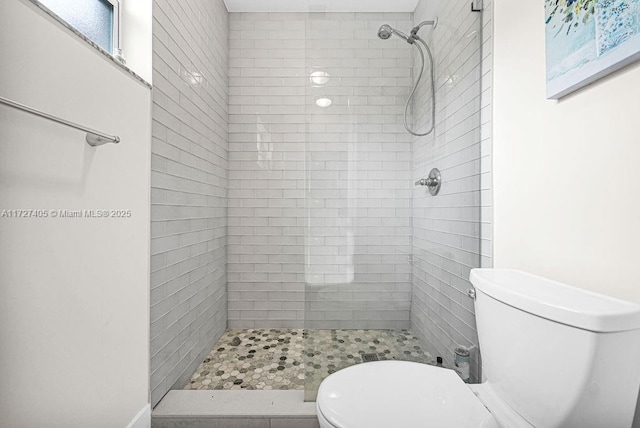 bathroom featuring toilet and a tile shower