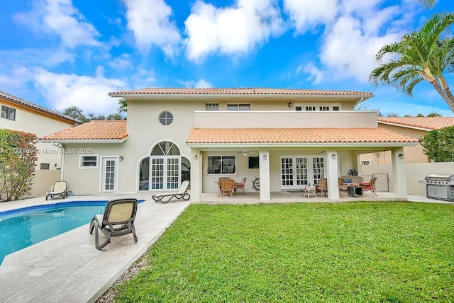 rear view of house featuring a patio, a lawn, french doors, and ceiling fan