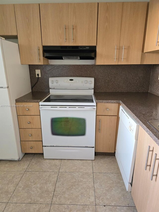 kitchen featuring light tile patterned floors, sink, and white appliances