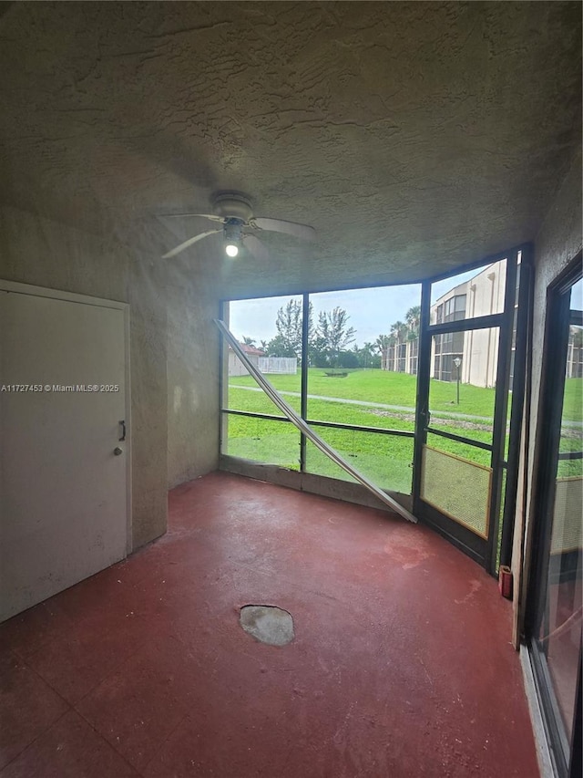 unfurnished sunroom featuring ceiling fan