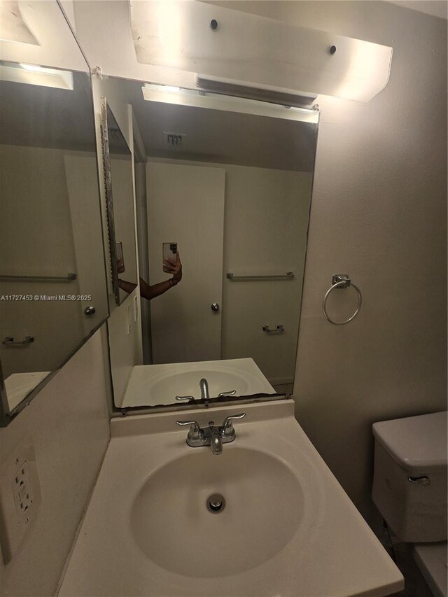 bathroom featuring toilet and vanity