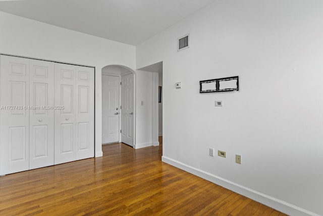 unfurnished bedroom with a closet and dark hardwood / wood-style floors