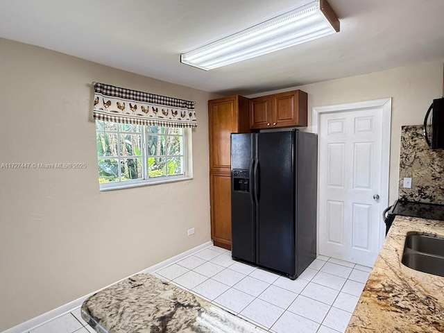 kitchen with sink, light tile patterned floors, and black appliances