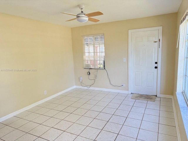 tiled spare room with ceiling fan and a wealth of natural light