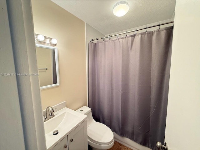 full bathroom with vanity, shower / tub combo, a textured ceiling, and toilet