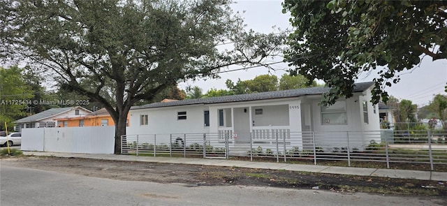 ranch-style house with covered porch and a fenced front yard