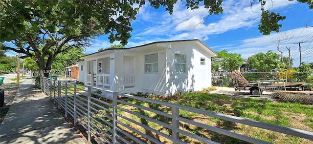 view of front of property featuring fence and stucco siding