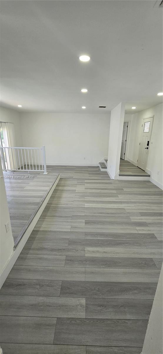 spare room featuring baseboards, wood finished floors, and recessed lighting