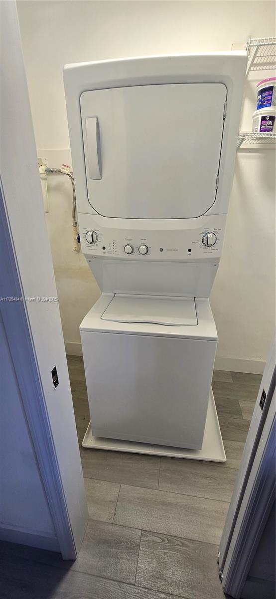 clothes washing area featuring stacked washer / drying machine