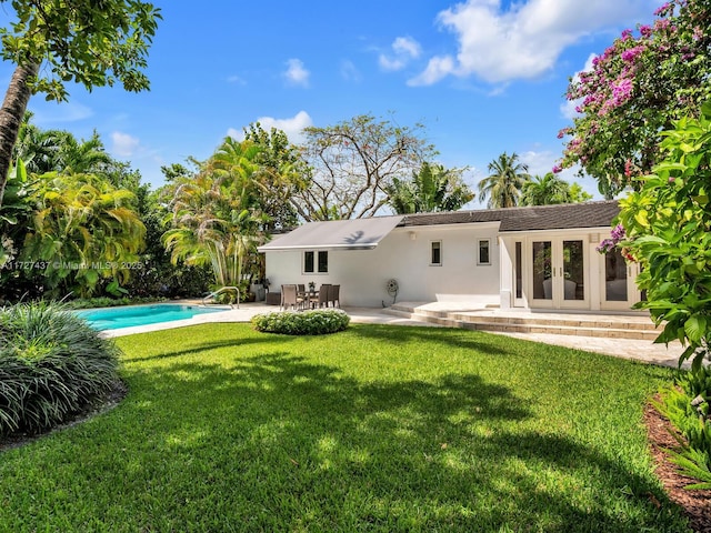 back of house with a yard and a patio