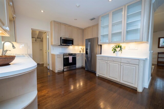 kitchen featuring dark wood-type flooring, stainless steel appliances, decorative backsplash, and sink