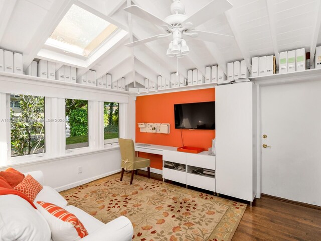 living room with ceiling fan, wood-type flooring, and lofted ceiling with skylight